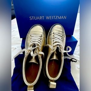 Stuart Weitzman gold sneakers.